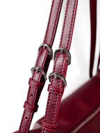 Close up of burgundy Willow Bag straps showing 4 silver buckles