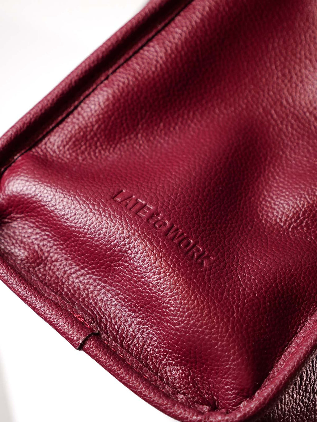 Close up of Willow Bag leather with 'Late to Work' embossed logo