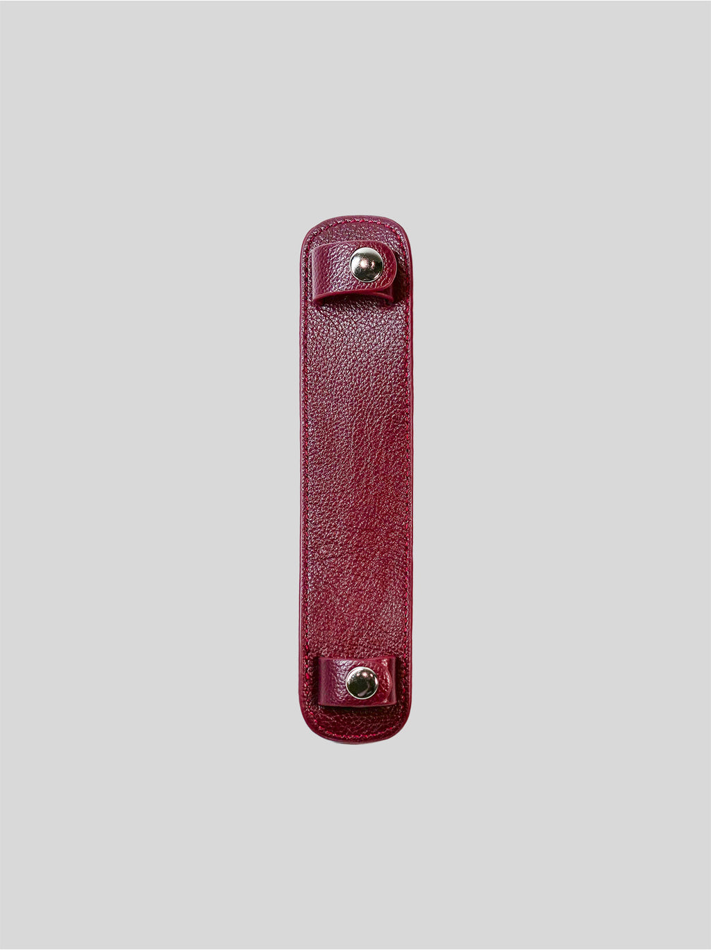 Red leather strap with metal buttons on a light gray background