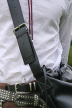 Sage crossbody bag black genuine leather  embossed logo on strap close up