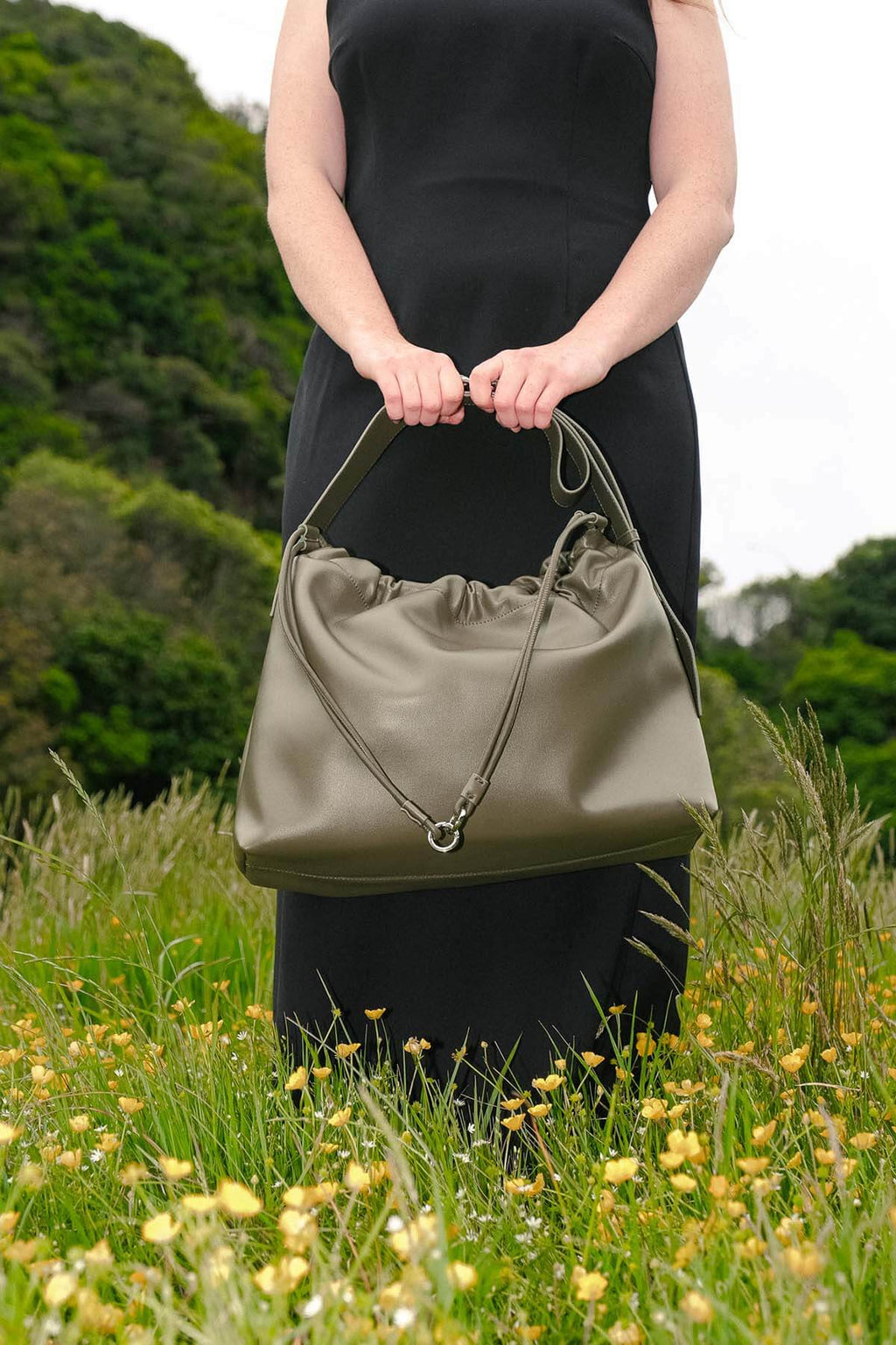 Sage Bag in green genuine leather held outdoors