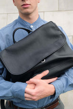 Black Amari top grain leather backpack held by model front view