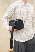 Black Fromont top grain leather crossbody bag held against body