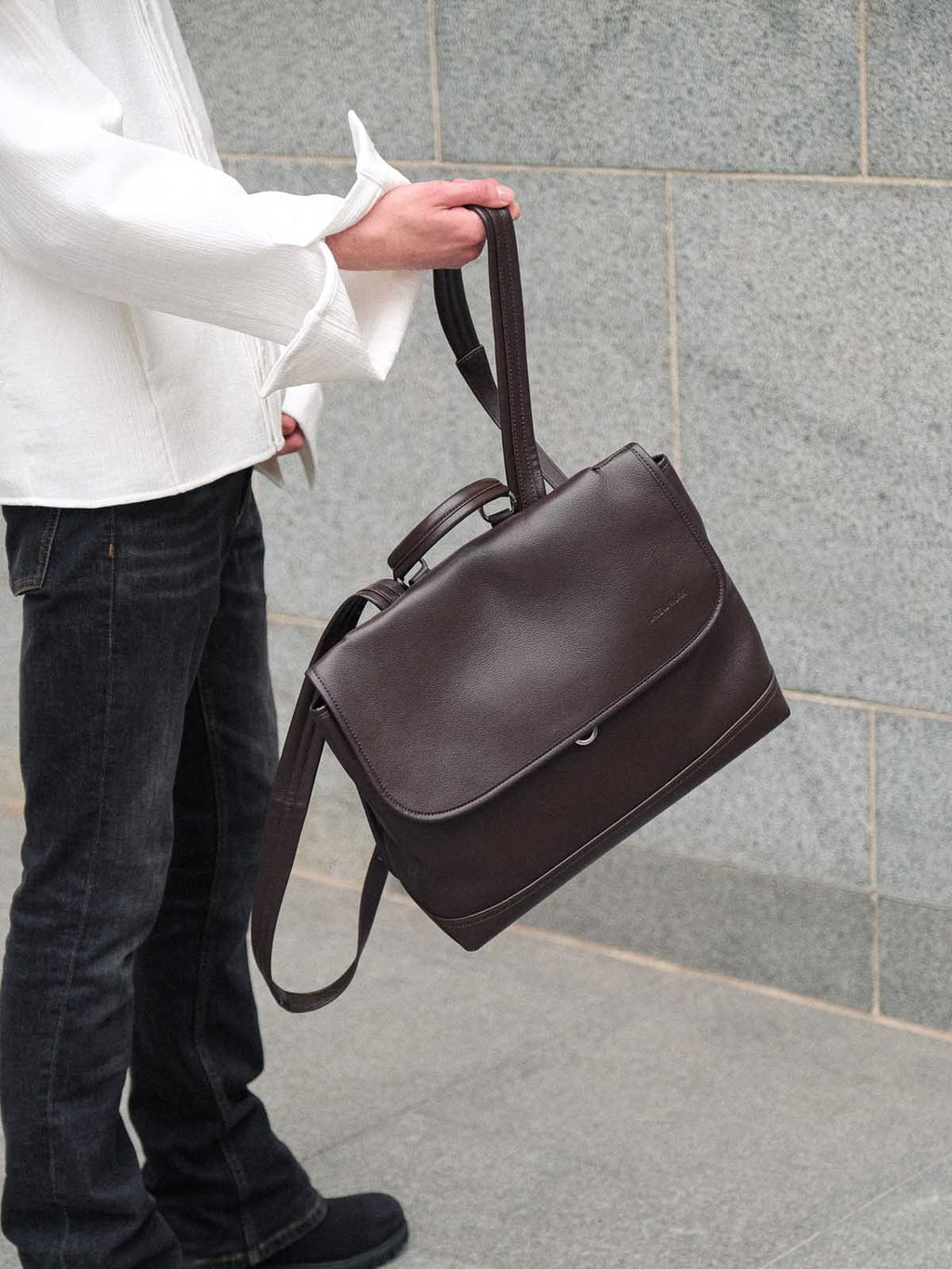 Brown Amari top grain leather backpack held with one strap