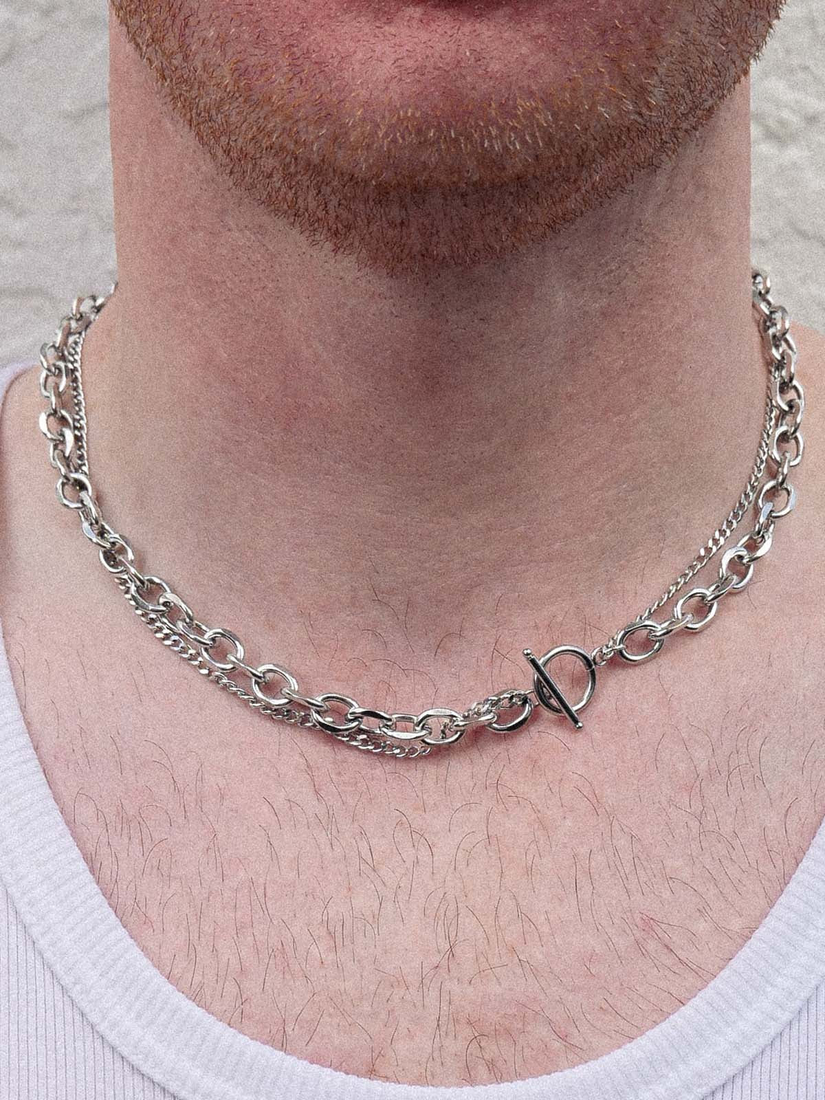 Silver chain necklace with a unique clasp worn by a person