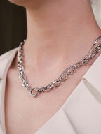 Silver chain necklace on a person wearing a white outfit