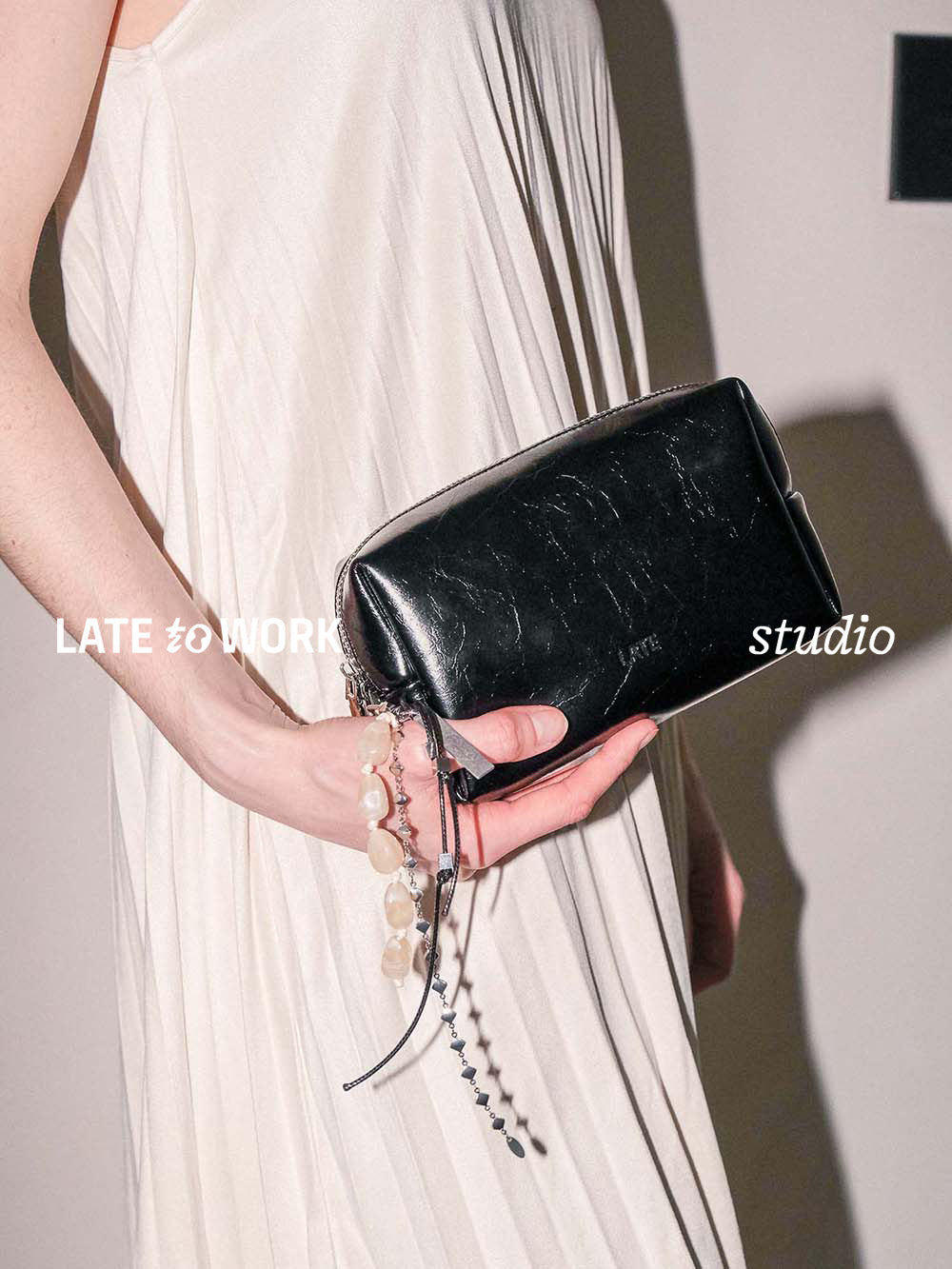 Kilian black leather toiletry pouch with charm clipped on