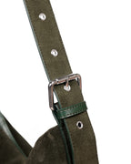 Close up of silver buckle on green suede strap