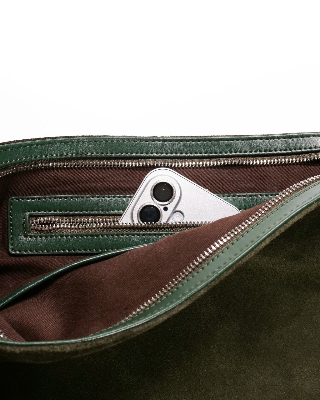 Close up of interior pocket in the forest medium Kite Bag showing an iPhone inside