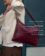 Medium burgundy Kite Bag with product features overlay: premium top grain leather, adjustable strap, 2 interior pockets, fits up to a 13-inch laptop