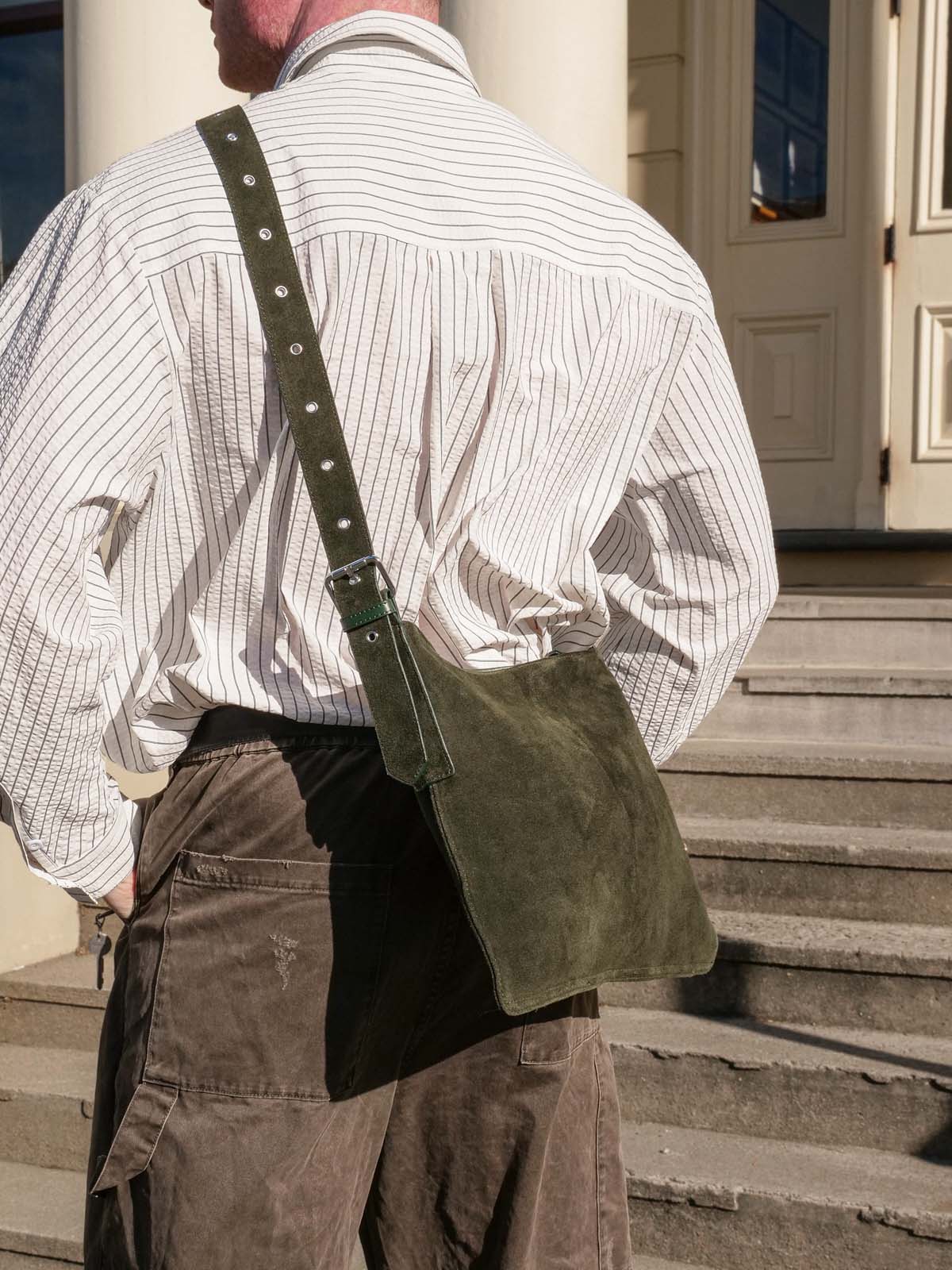 Back of man wearing forest suede medium Kite crossbody