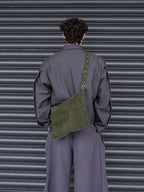 Man facing away from the camera wearing the forest suede medium Kite crossbody on his back