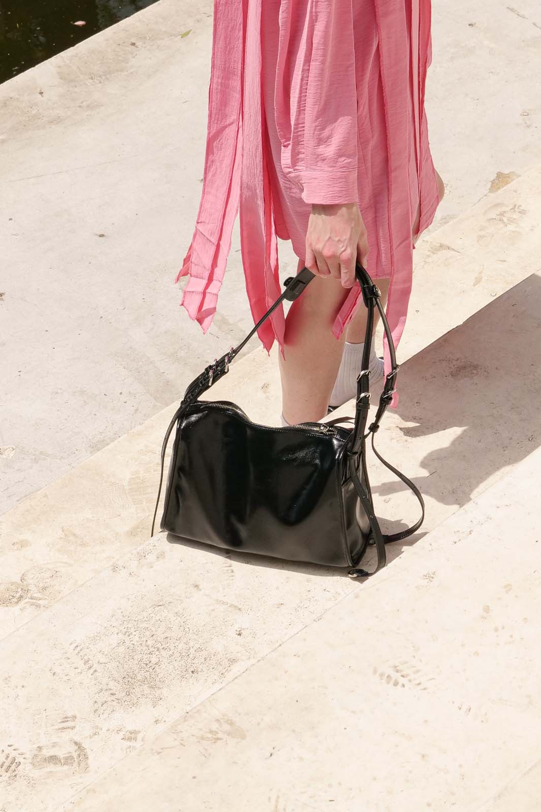 Black patent small Willow Bag on stone steps