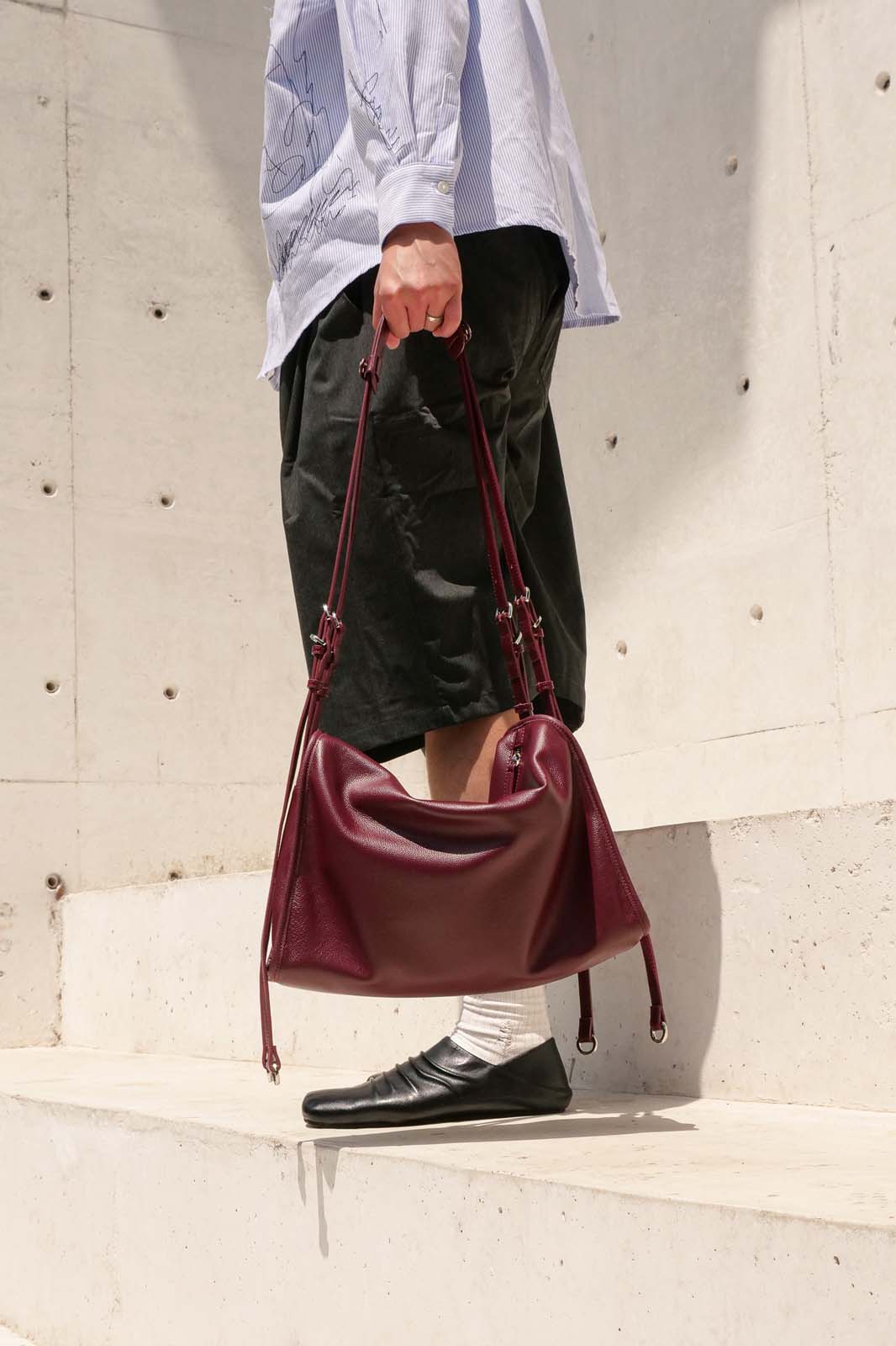 Front view Burgundy Willow Bag held by side 