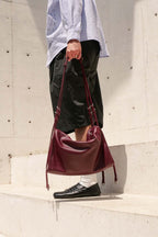 Front view Burgundy Willow Bag held by side 