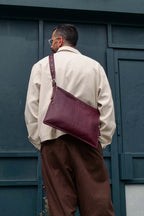 Man wearing medium burgundy Kite Bag crossbody, shot from behind