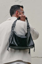 Man holding small black Willow Bag against a plain background