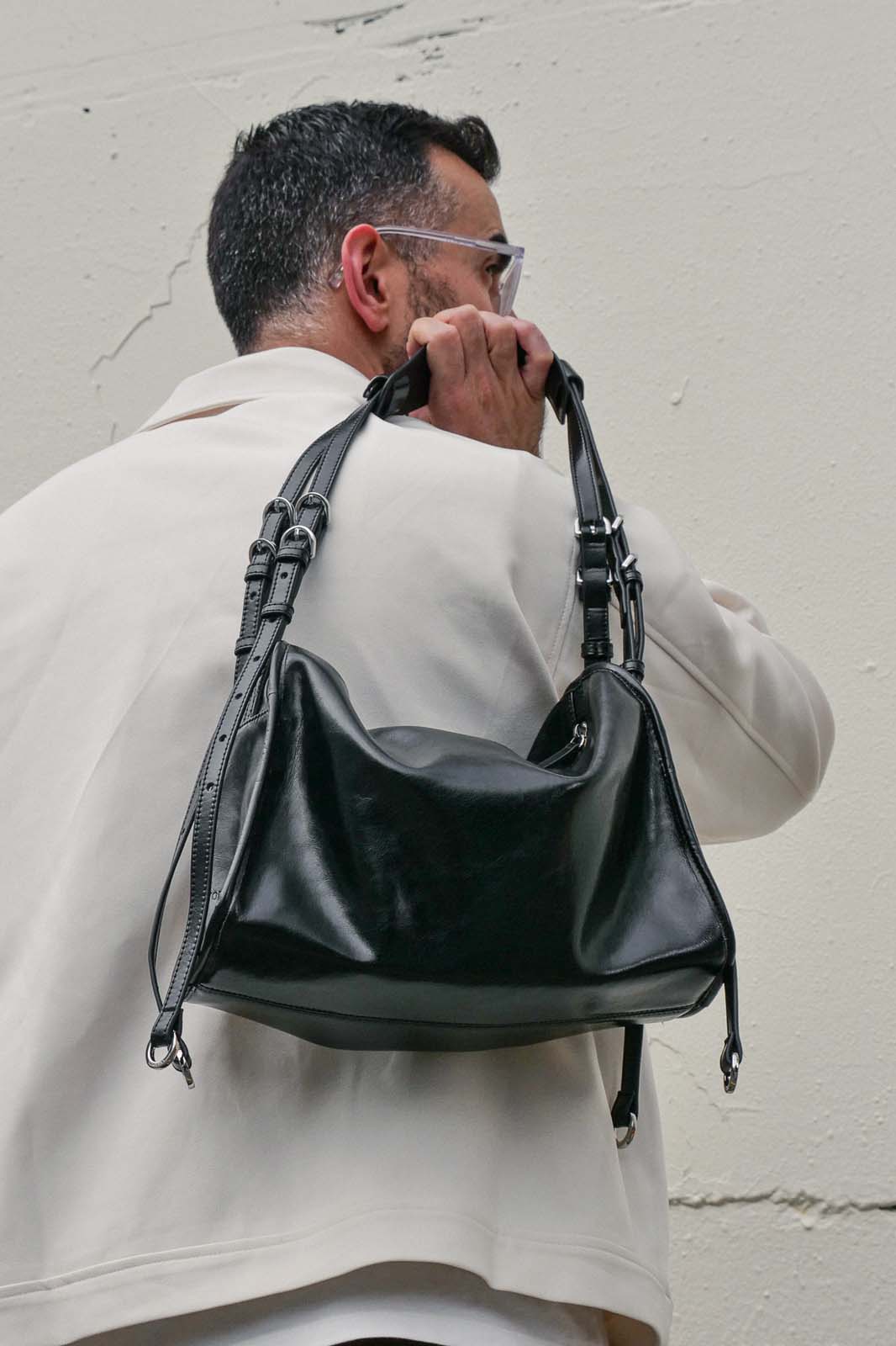 Man holding small black Willow Bag against a plain background