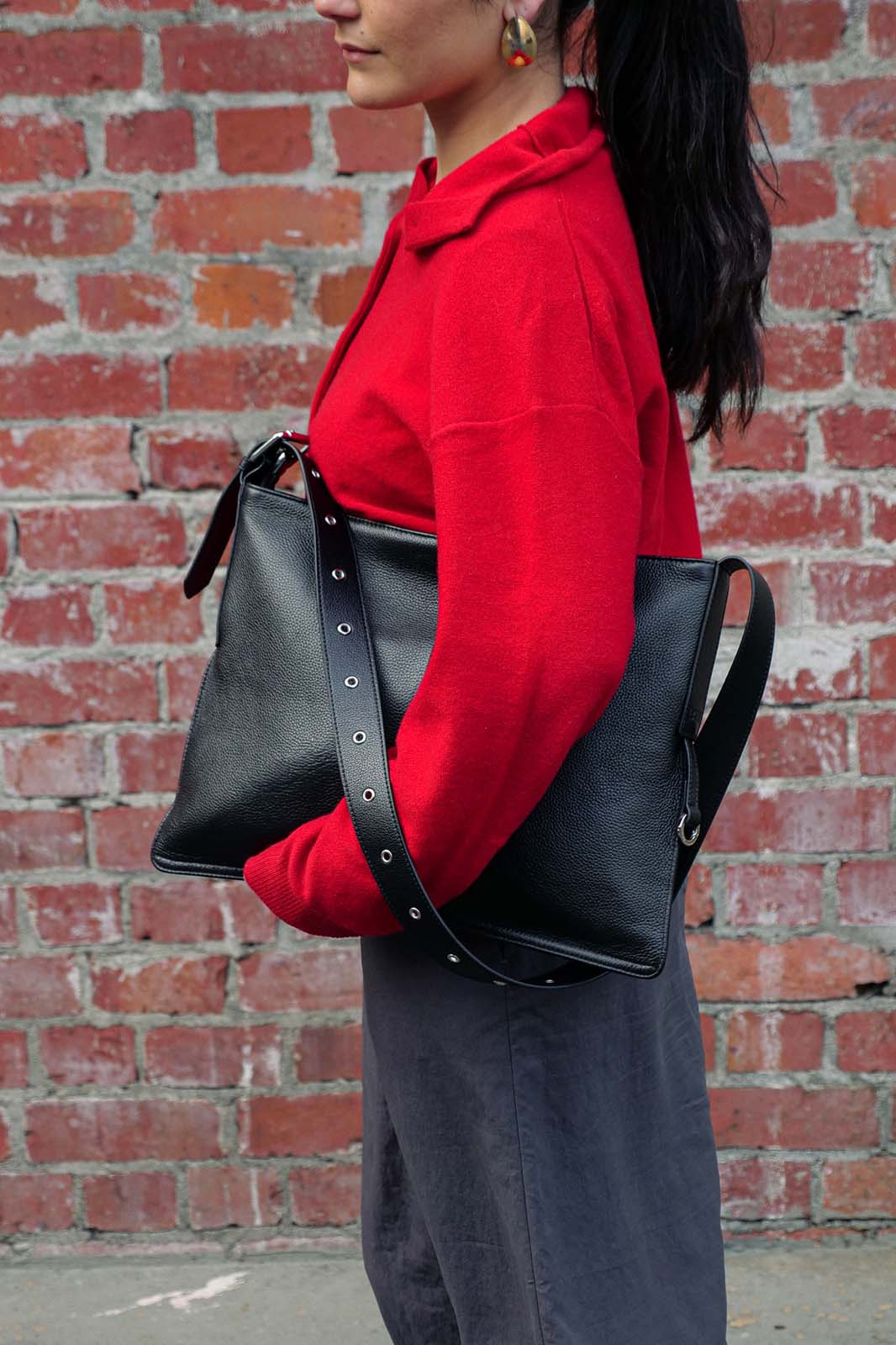 Black medium Kite Bag held under arm