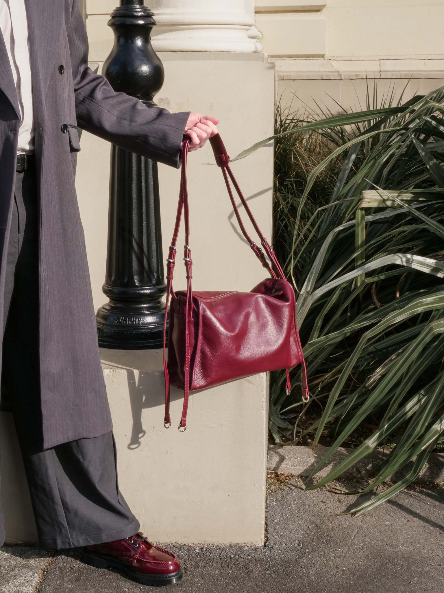 Burgundy Willow Bag resting outdoors on concrete steps