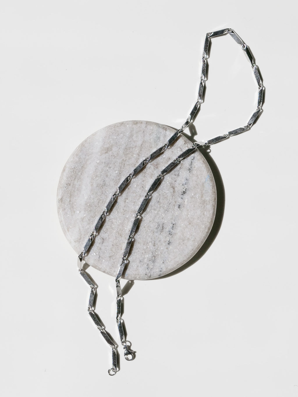 Prism Necklace laid on a stone surface