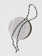 Prism Necklace laid on a stone surface