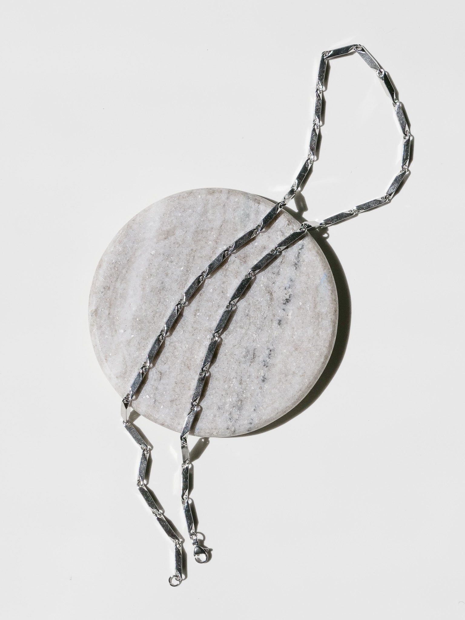 Prism Necklace laid on a stone surface