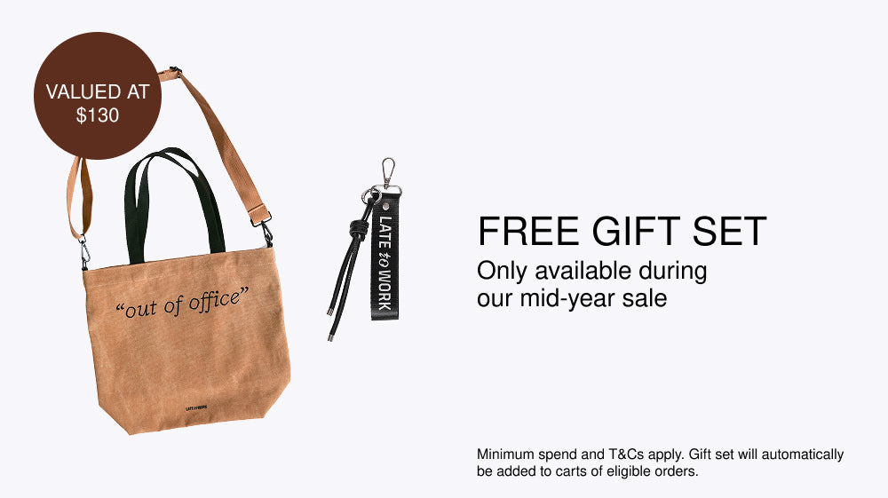 Brown bag with 'out of office' text and black strap, valued at $130, on a white background with promotional text for a free gift set during a mid-year sale.