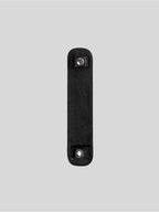 Black top-grain leather bag strap shoulder pad isolated on grey background
