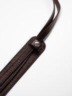 Brown shoulder pad with 2 straps buttoned in