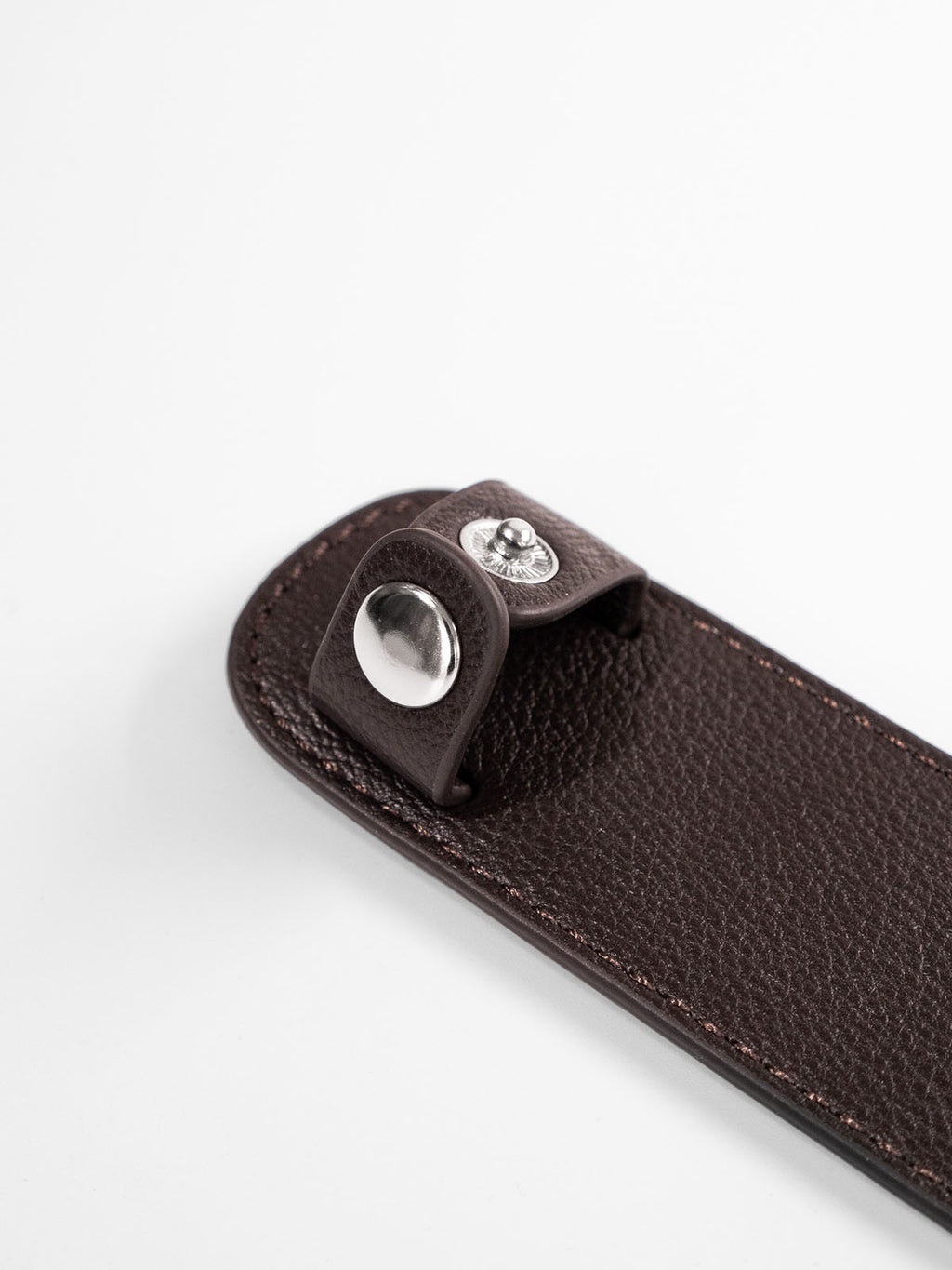 Brown shoulder pad close up of silver button closure