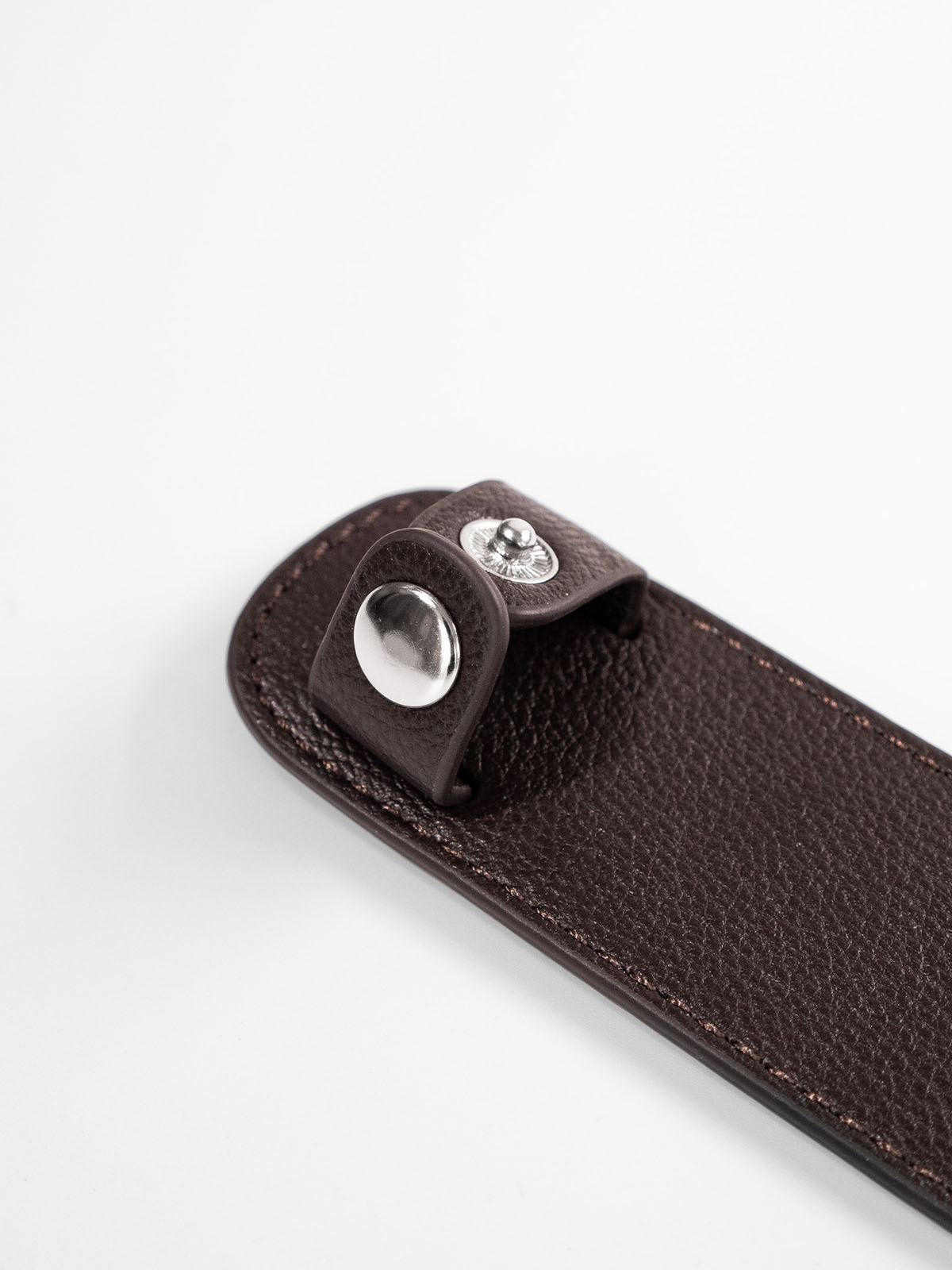 Brown shoulder pad close up of silver button closure