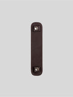 Brown top-grain leather bag strap shoulder pad isolated on grey background