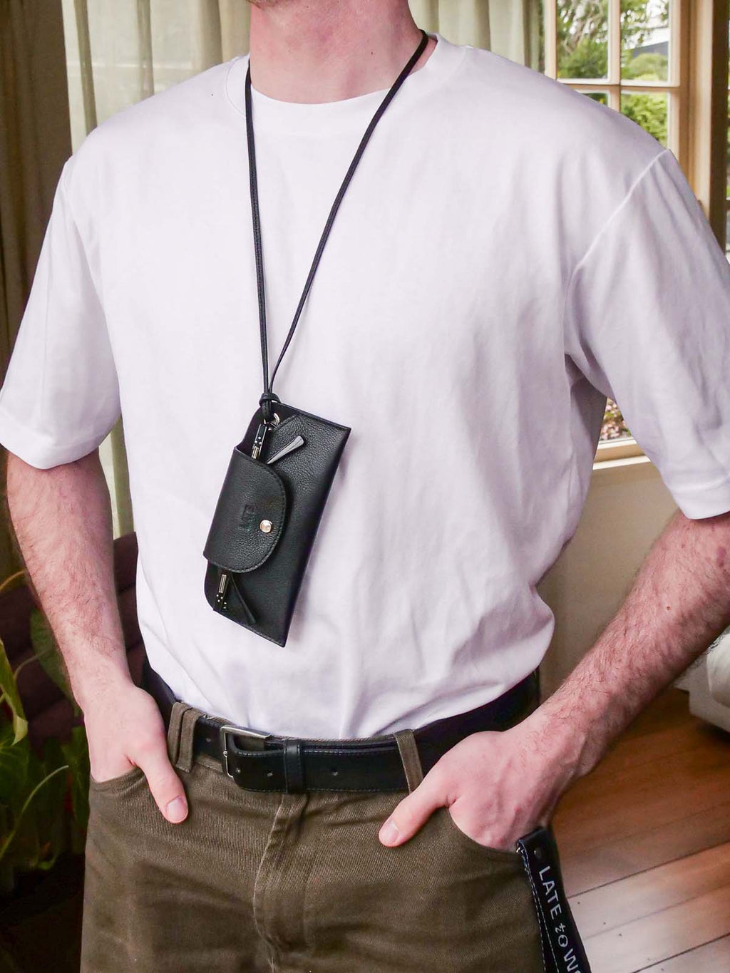 Person wearing the Late to Work sunglasses case around their neck