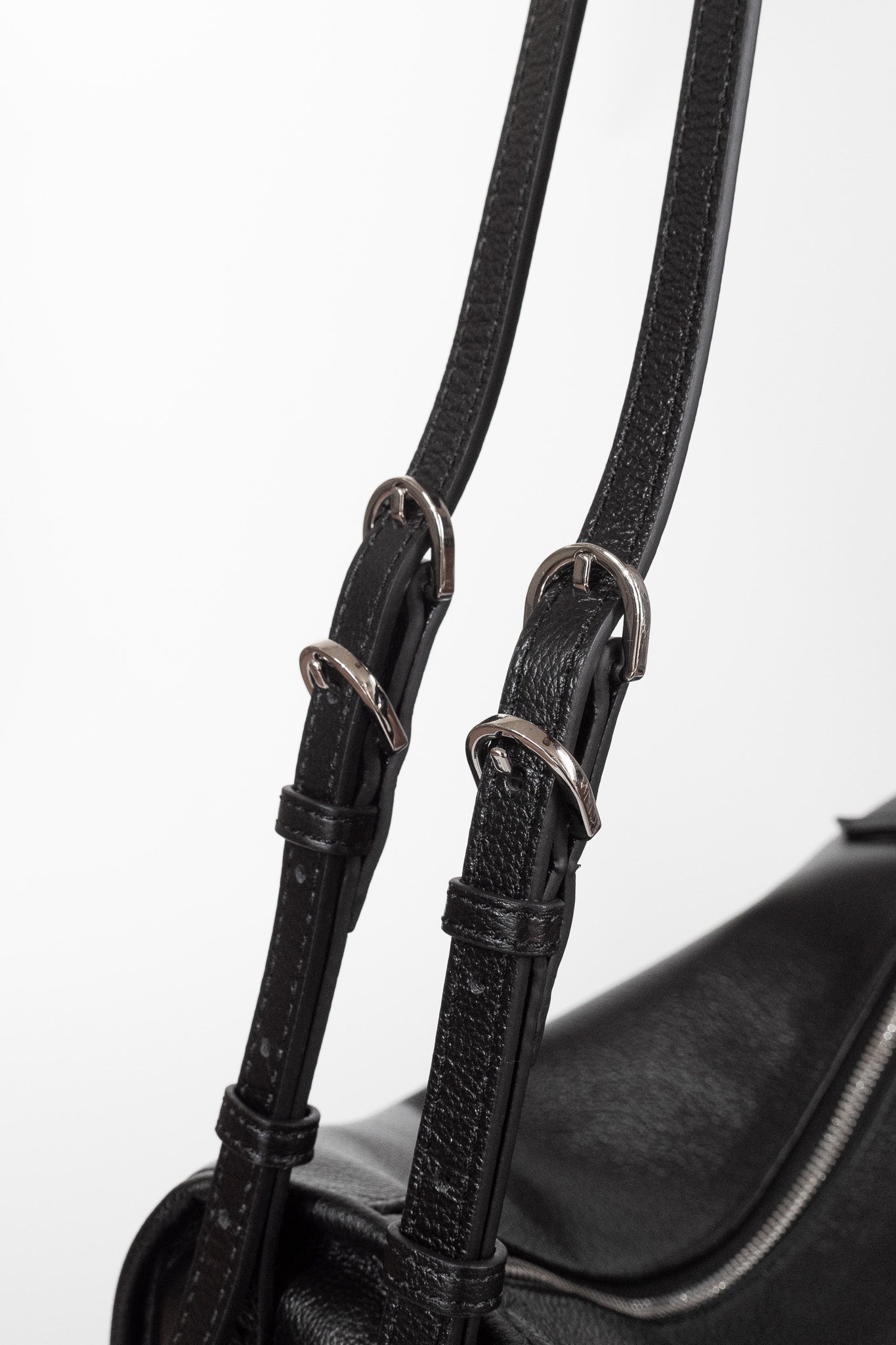 Black Willow Bag close up of double straps featuring quadruple silver buckle hardware 