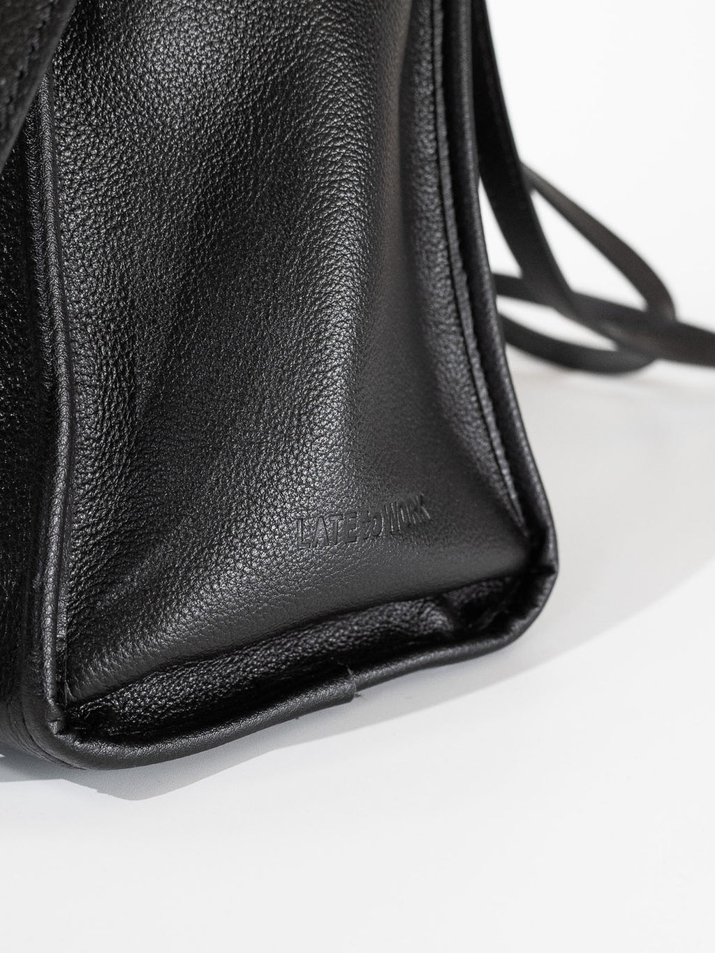 Black Willow Bag close up of embossed 'Late to Work' leather on side of bag