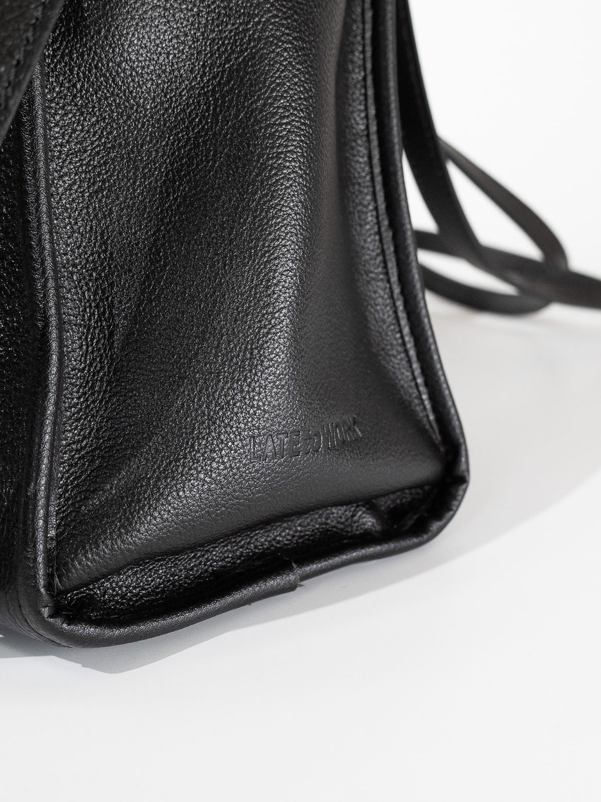 Black Willow Bag close up of embossed 'Late to Work' leather on side of bag