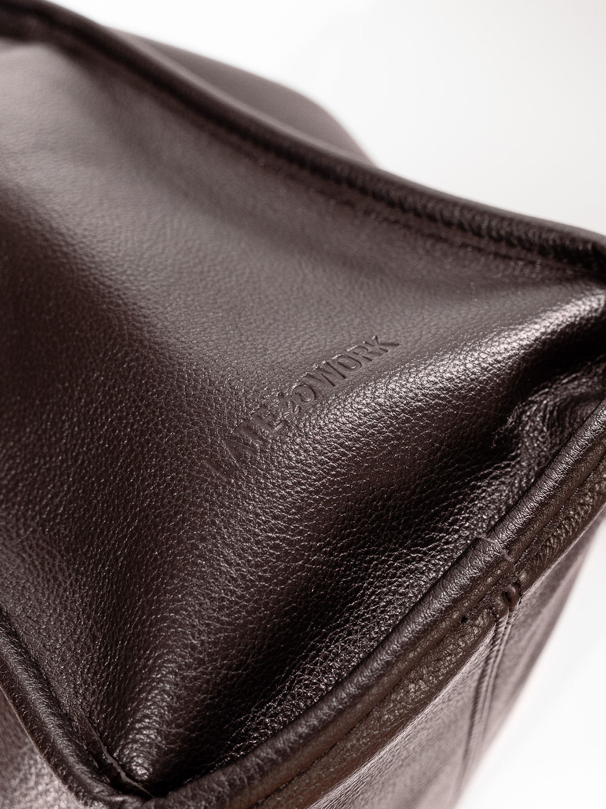 Brown Willow Bag close up of embossed 'Late to Work' leather on side of bag